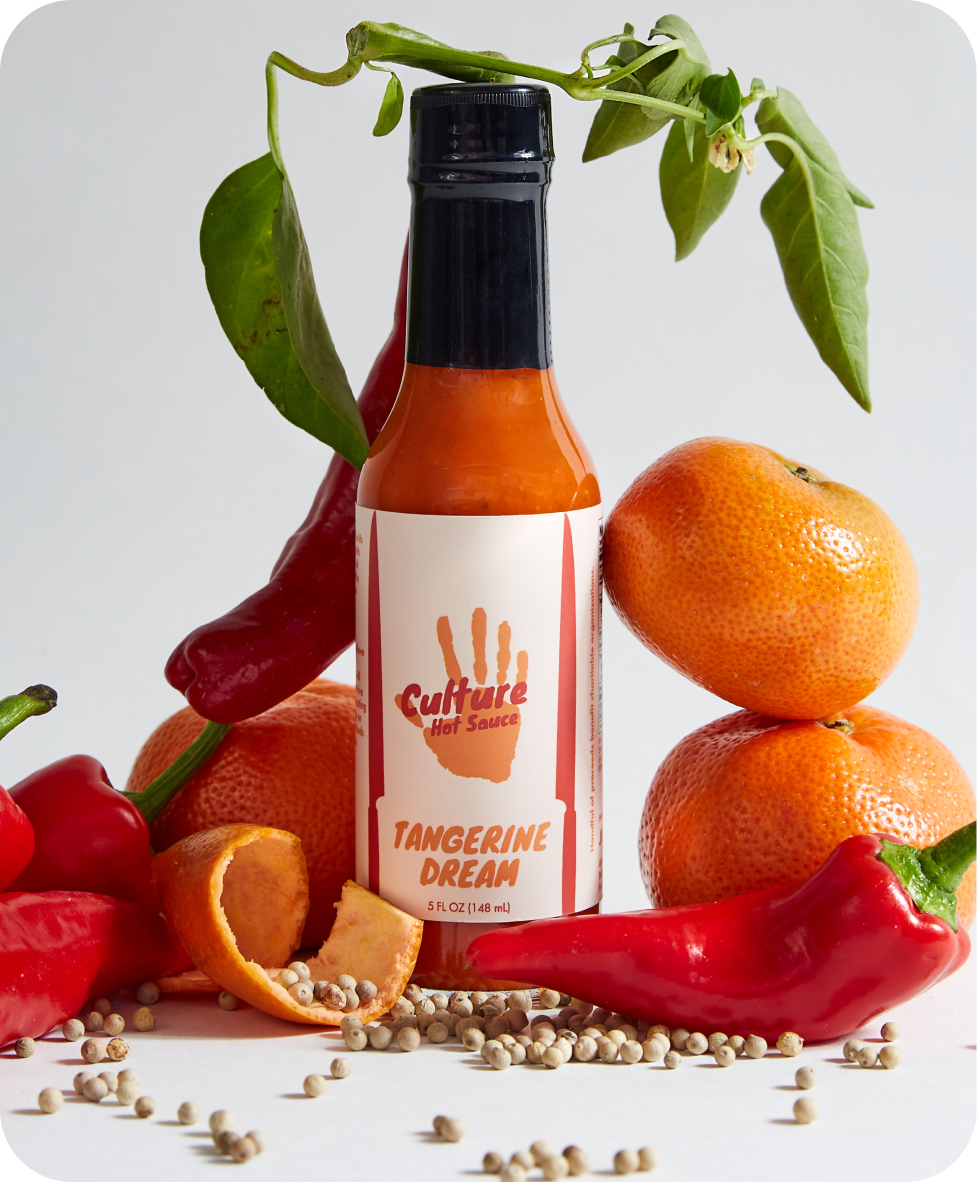 Tangerine Dream Hot Sauce –A bright tangerine citrus base with a hint of yuzu, sweet peppers, and silky coconut cream for a smooth, slightly sweet flavor profile. This vibrant sauce is perfect for those who crave a balanced blend of citrusy brightness and savory depth.
Ingredients: Onion, Tangerine, Vinegar, Sweet Pepper, Coconut Cream, Garden Peppers, Sea Salt, Lemon, Lime, Paprika, Yuzu, White Pepper, Szechuan Peppercorn
Great On: Eggs, ceviche, fish, breakfast dishes, pork, hot dogs, quesadillas, chicken