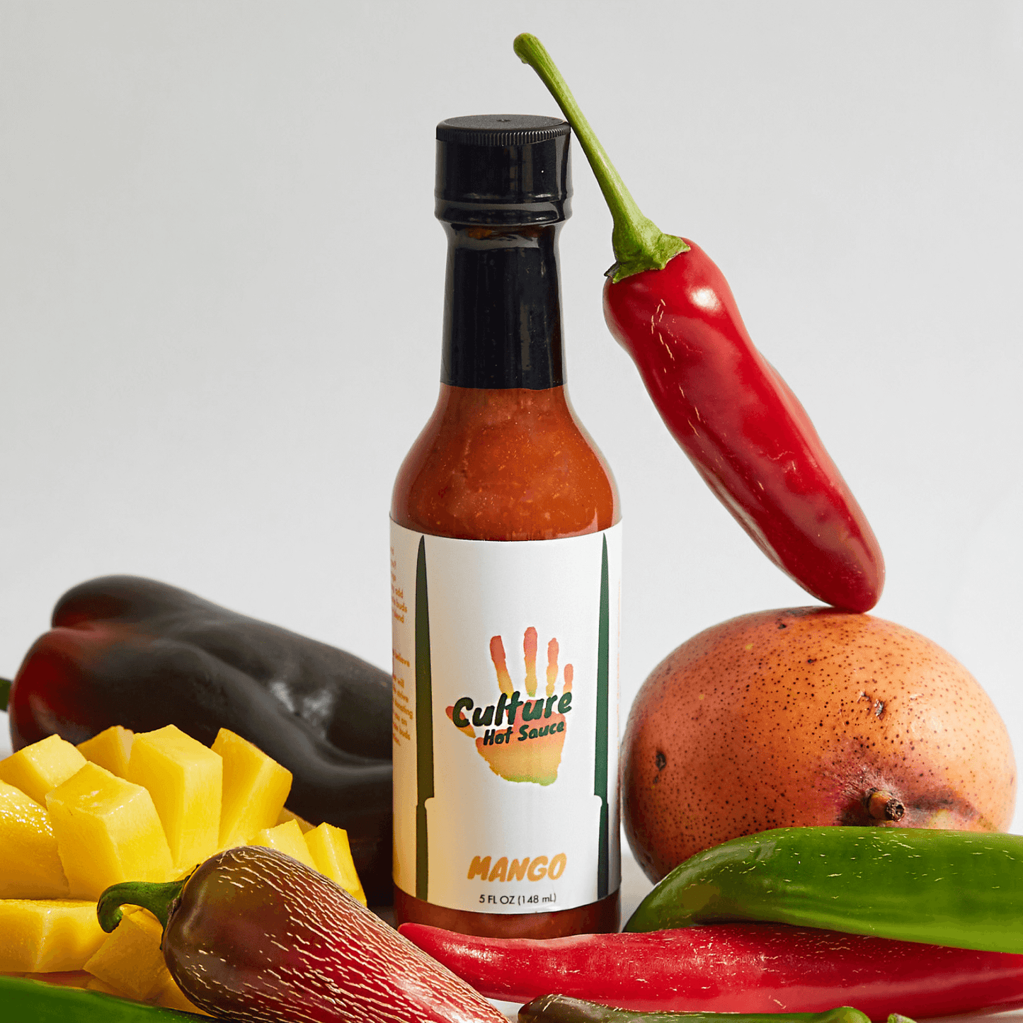 Mango hot sauce, curry, sweet heat, Serrano chili, like a mango chutney, ingredients surrounding hot sauce