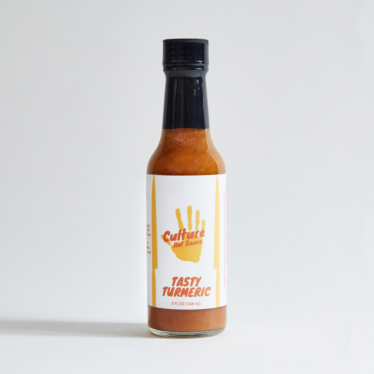 tasty turmeric hot sauce bottle, golden milk, fresh turmeric root, cream, leatherwood honey, black pepper