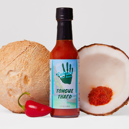 A bottle of Culture Hot Sauce labeled 'Tongue Thai'd' stands centered between a whole coconut, a halved coconut with red sauce inside, and a red chili pepper on a light gray background.
