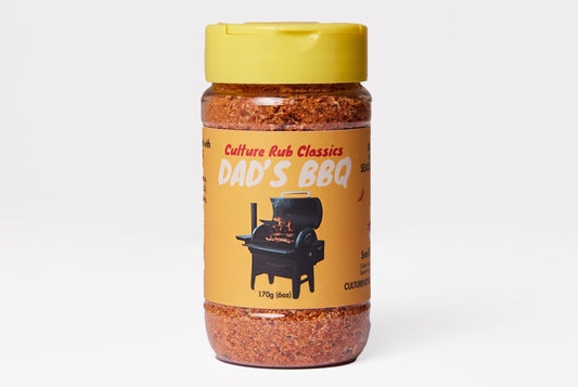 A jar of Culture Rub Classics Dad's BBQ rub salt, featuring a yellow lid and a yellow label with a black grill illustration, set against a light gray background.